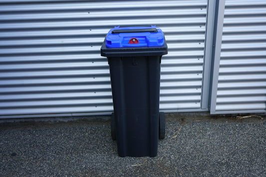 Blå affaldscontainer 140 liter med hjul set forfra – robust skraldespand til udendørs affaldssortering