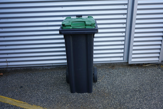 Grøn affaldscontainer 140 liter med hjul set forfra – robust udendørs skraldespand til affaldssortering