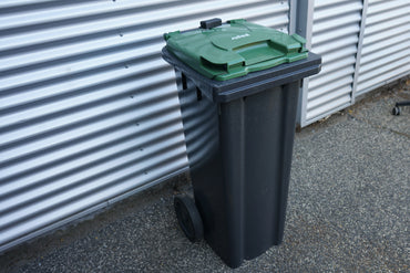 Affaldscontainer grøn 140 liter med hjul set fra venstre side – praktisk skraldespand til husholdning og erhverv