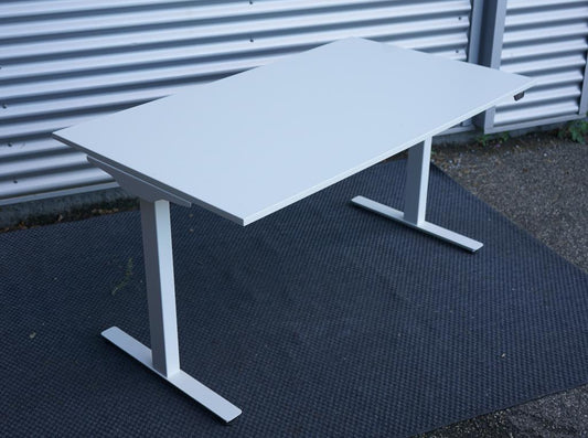 AJ Products hæve-sænkebord 140x80 cm med hvid rektangulær bordplade, set fra skrå vinkel med elektrisk højdejustering.