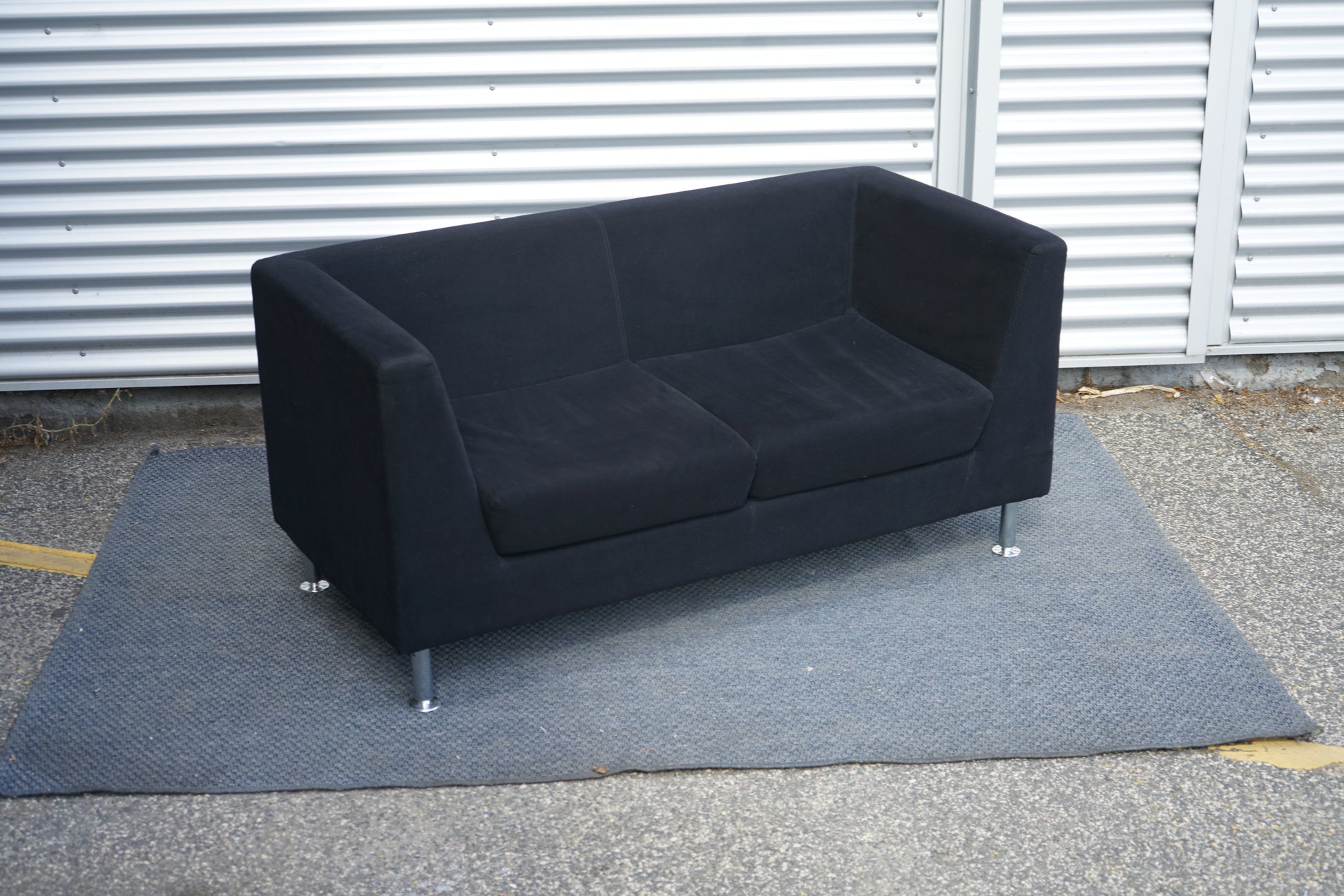 Antares 2-personers sofa 145x65 cm i mørkeblå stof set fra skrå vinkel med forkromede ben