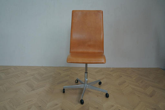 Oxford kontorstol i cognacfarvet læder med hjul, set forfra – designet af Arne Jacobsen for Fritz Hansen