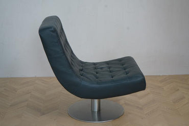 Sidevisning af Arne Norell loungestol i sort læder med drejestel og elegant profil