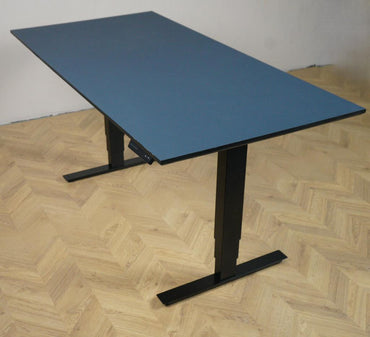 Arnehus hæve-sænkebord i mørkeblå linoleum med elektrisk justerbart stel set i skrå vinkel. Moderne ergonomisk skrivebord 160x80 cm.
