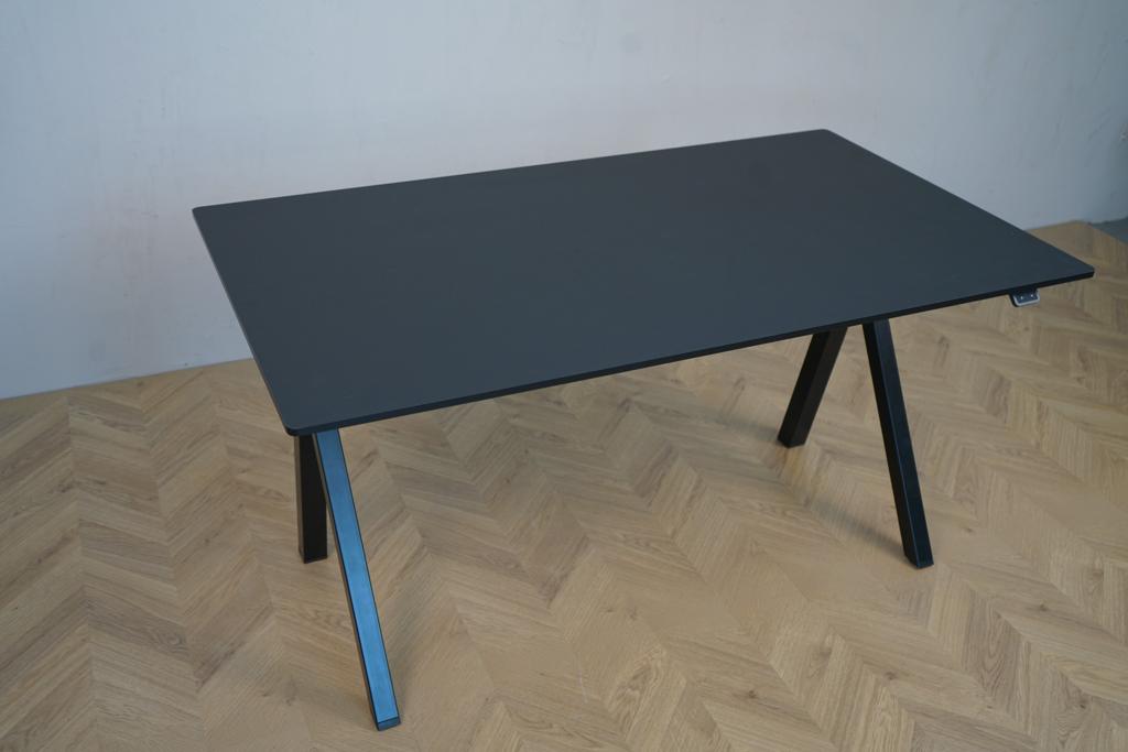 Skråt billede af Arnehus hæve-sænkebord i sort linoleum med elegant design og funktionel højdejustering