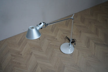 Artemide Tolomeo designerbordlampe i aluminium med rund fod og justerbar lampearm, set ovenfra.