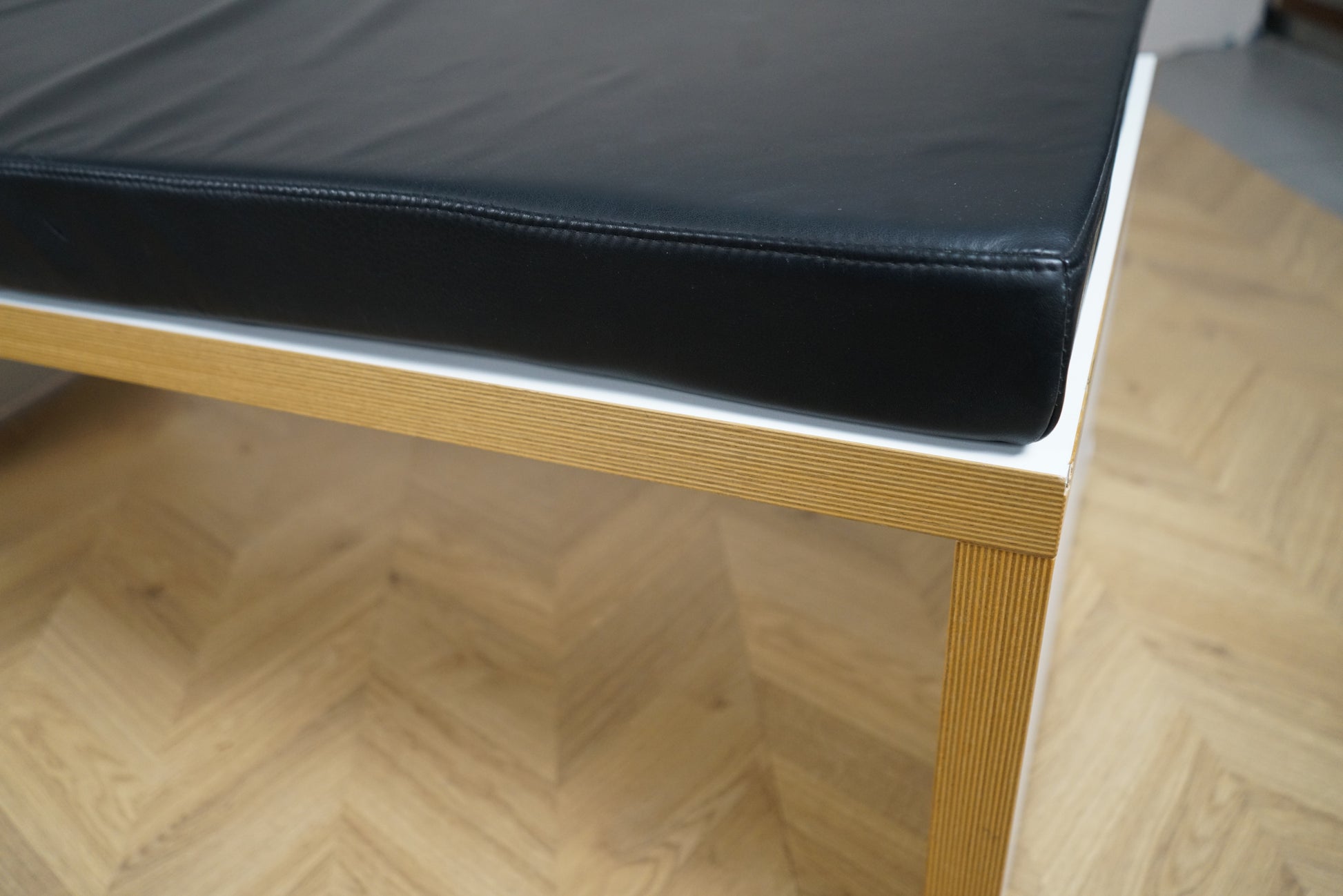 Nærbillede af bænk med sort hynde og trædetaljer – solid og stilren siddeplads til kontor og lounge