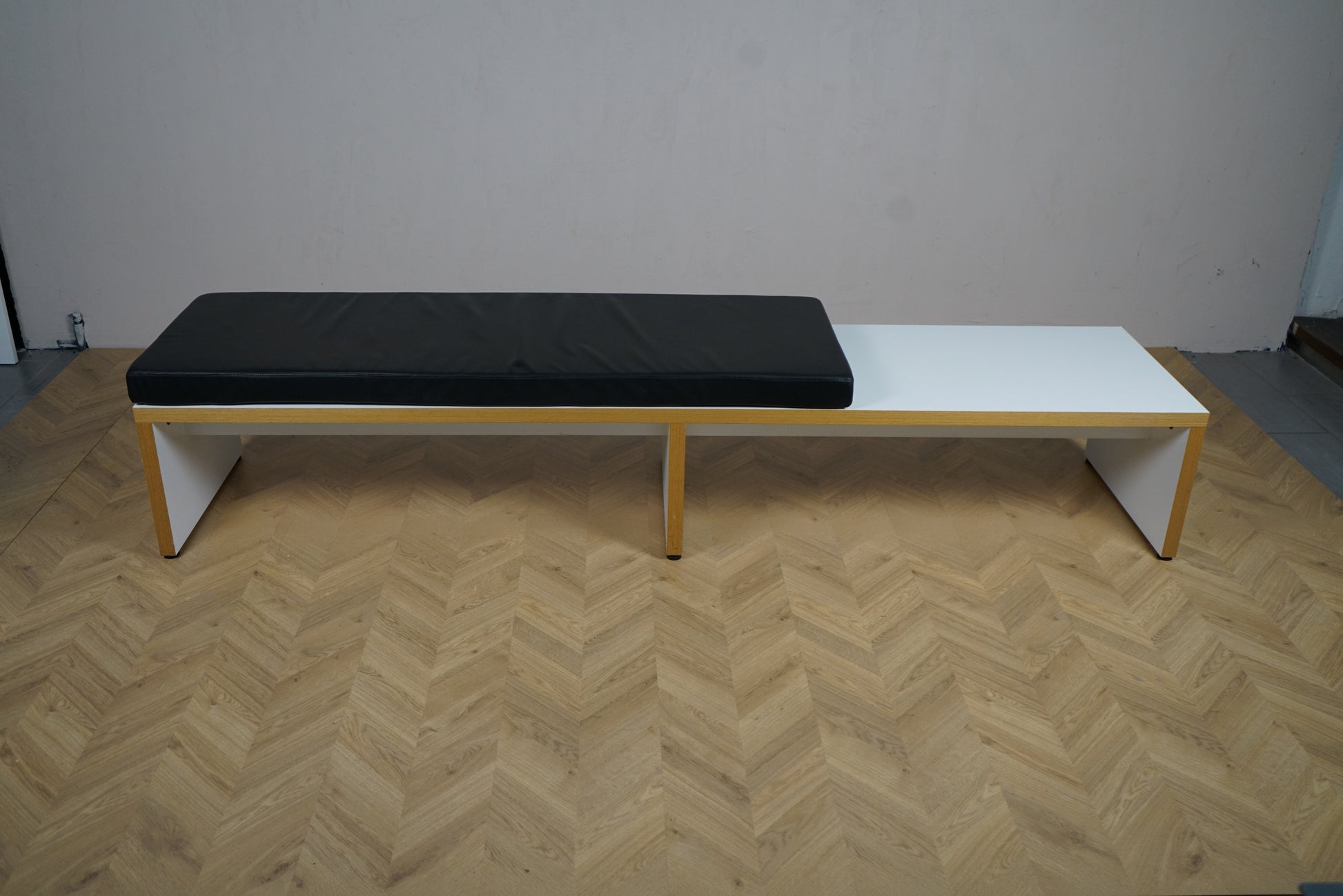 Bænk med sort hynde set på afstand, 255x60x43 cm – stilren siddeplads til kontor, lounge og arbejdsplads