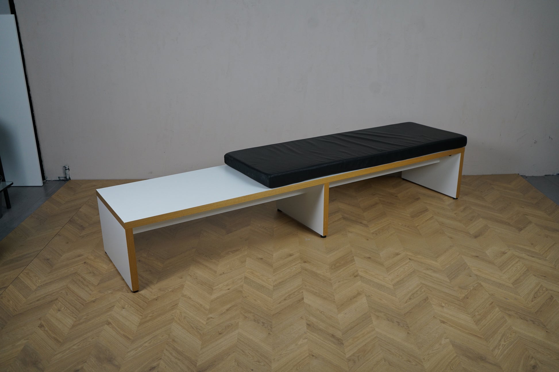 Bænk 255x60x43 cm med sort hynde set skråt fra højre side – velegnet til lounge, skoler og kontorer