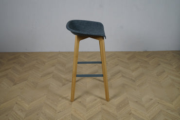 Moderne barstol med gråt buet sæde og egetræsben – set fra siden, siddehøjde 74 cm