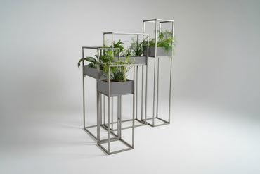 Blomsterstativ i metal set fra siden med råt industrielt udtryk og plantekasser