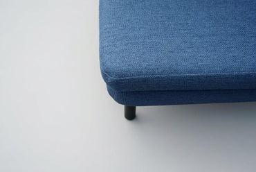 Nærbillede af Bolia samtalesofa med blå polstring og afrundede armlæn i moderne skandinavisk design.