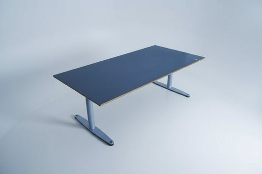 Bondo hæve-sænkebord 180x90 cm med sort linoleum og affasede kanter, set fra skrå vinkel med Linak-stel og kabelbakke.