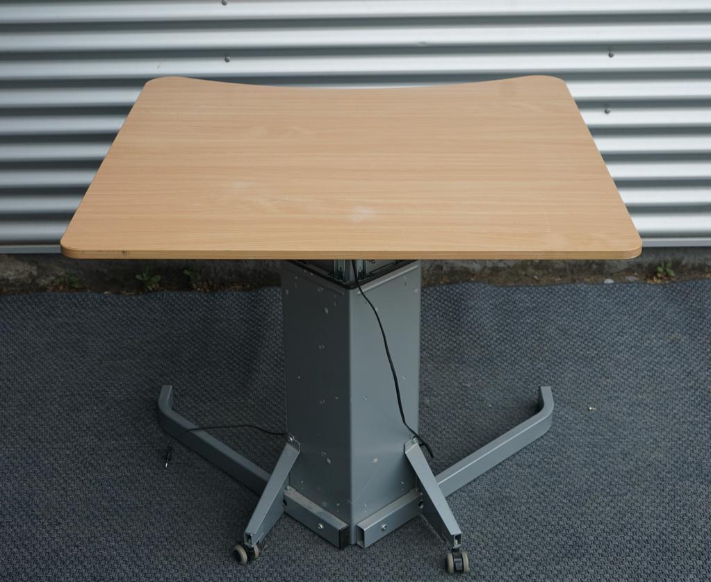 Conset hæve-sænkebord i bøg 100x100 cm – set bagfra med låsbare hjul