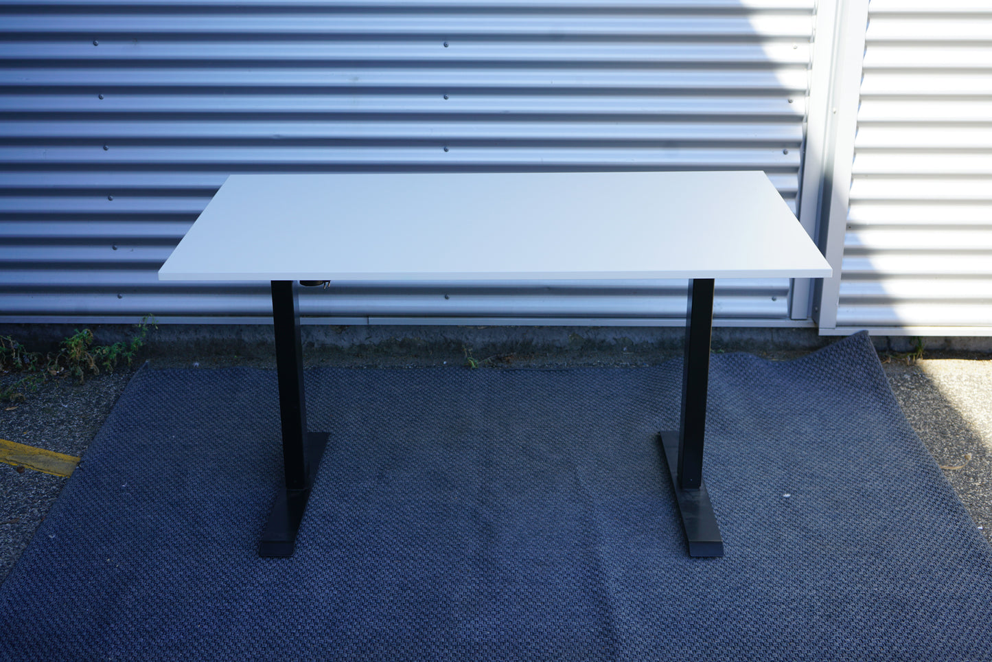 Conset hæve-sænkebord 140x80 i hvid laminat med sort stel set bagfra