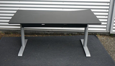 Bagfra-visning af Cube Design hæve-sænkebord i sort med solidt stel og kabelstyring.