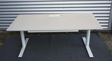 Frontvisning af Dencon Delta hæve-sænkebord med beige linoleum og elegant stel.