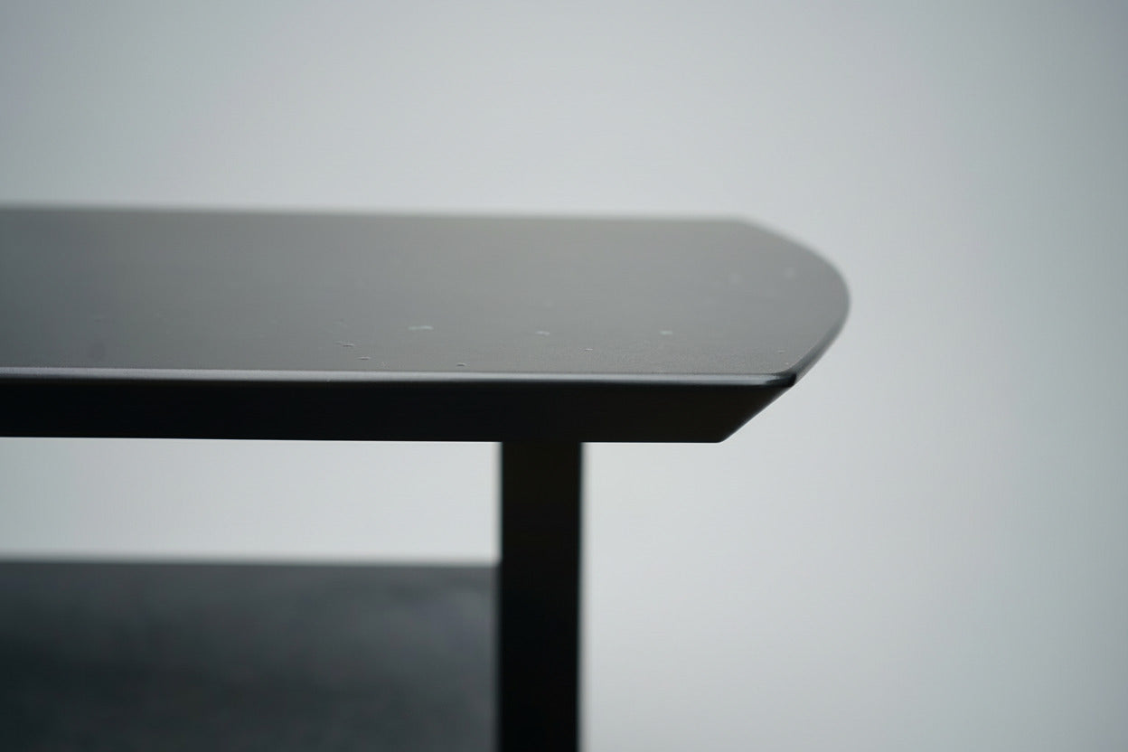 Close-up af Dencon Delta bordplade i sort linoleum med affasede kanter.