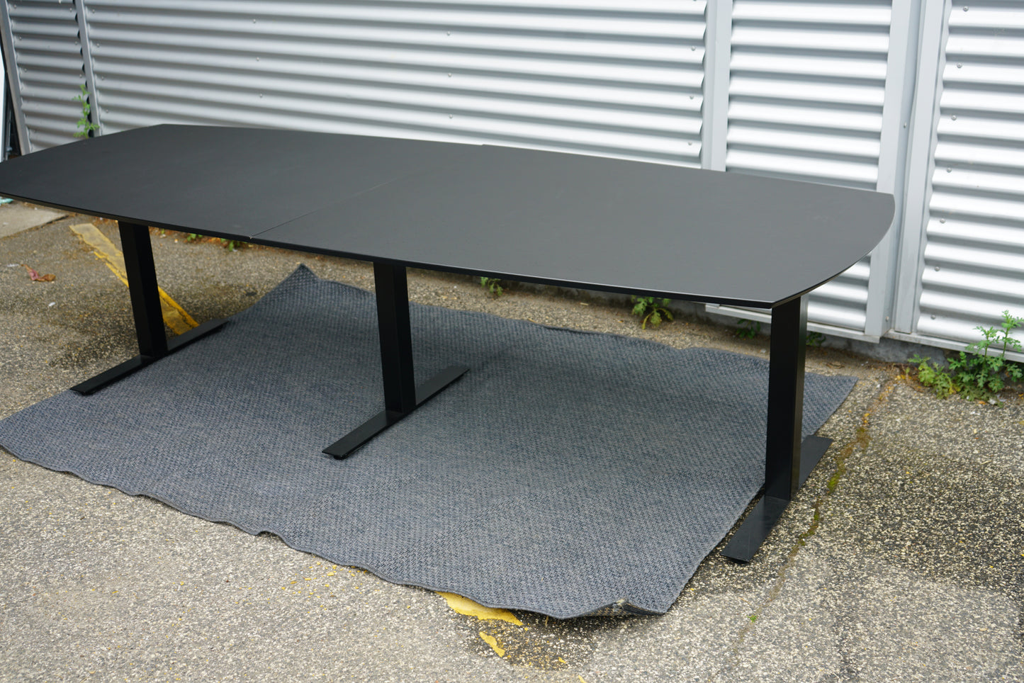 Sidevisning af Dencon Delta konferencebord i sort med affasede kanter.