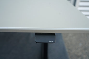 Nærbillede af knapper til hæve-sænkefunktion på Dencon Delta skrivebord med ergonomisk Linak kontrolpanel