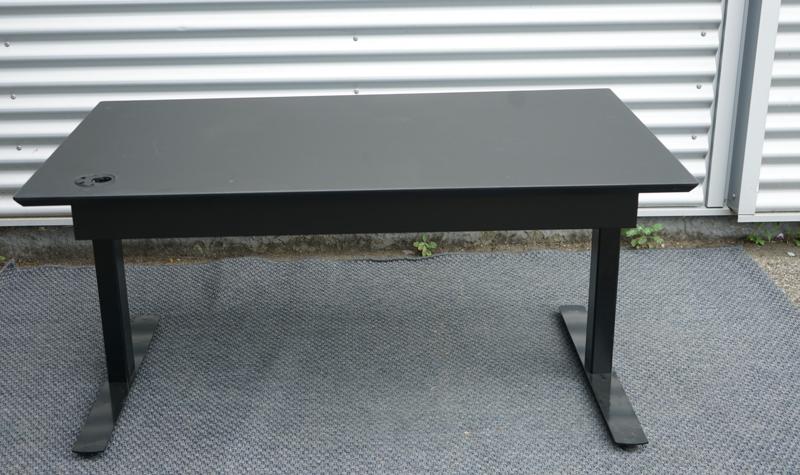 Dencon hæve-sænkebord 130x80 set bagfra med kabelbakke og sort understel.