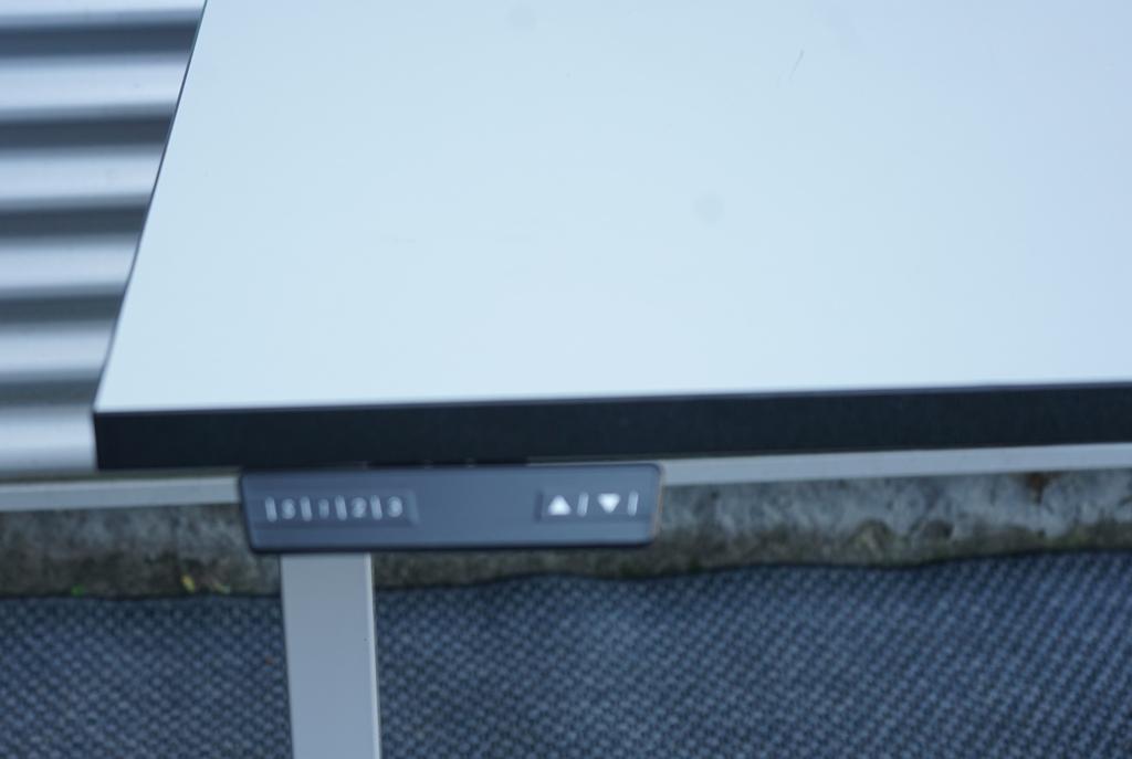 Close-up af Dencon hæve-sænkebord 140x80 med detalje af hvid bordplade og memory funktion.