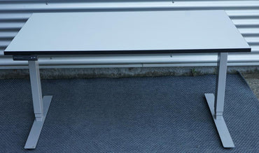 Frontbillede af Dencon hæve-sænkebord 140x80 med hvid bordplade og gråt stel.