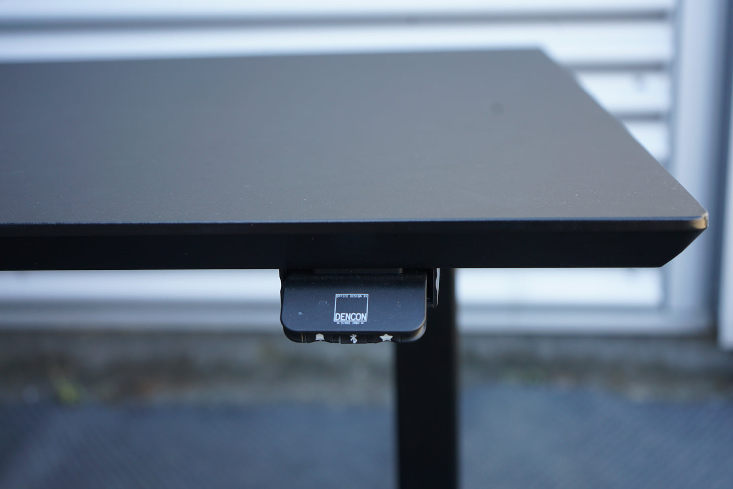 Dencon hæve-sænkebord 140x80 i sort linoleum med sort stel set fra skrå vinkel
