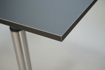 Close up af Dencon hæve-sænkebord i sort linoleum med bordplade og kant