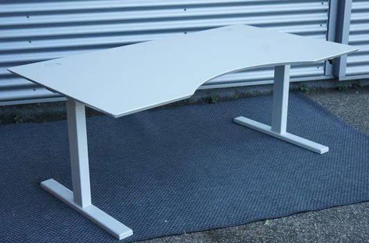 Dencon hæve-sænkebord 160x90 med hvid laminat bordplade og hvidt stel set fra skrå vinkel.