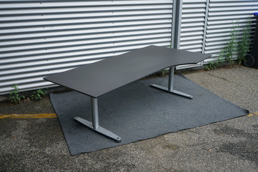 Skrå visning af Dencon hæve-sænkebord 180x100 cm sort højrevendt med linoleum bordplade og Linak-motor