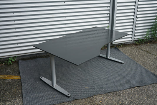 Skrå visning af Dencon hæve-sænkebord 180x100 cm i sort med venstrevendt linoleum bordplade og kabelbakke