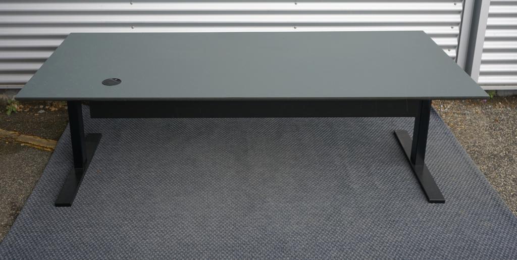Dencon hæve-sænkebord i mørkegrå set bagfra med elektrisk stel og sort kabelbakke. Robust og stilrent arbejdsbord i mål 200x90 cm.
