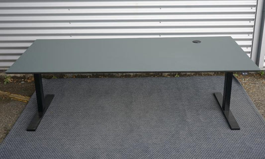 Dencon hæve-sænkebord i mørkegrå linoleum set forfra. Elektrisk højdejusterbart bord med kabelgennemføring og sort kabelbakke, mål 200x90 cm.