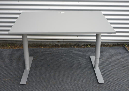 Frontvisning af Denconi hæve-sænkebord 120x80 cm med lysegrå laminatbordplade og robust T-stel.