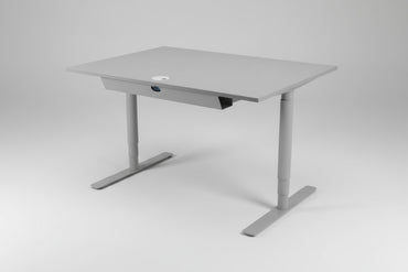 Denconi hæve-sænkebord 120x80 cm i lysegrå laminat med robust T-stel, set fra skrå vinkel.
