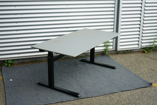 Duba B8 hæve-sænkebord 160x80 cm i lysegrå linoleum set fra skrå vinkel med affasede kanter og kabelbakke