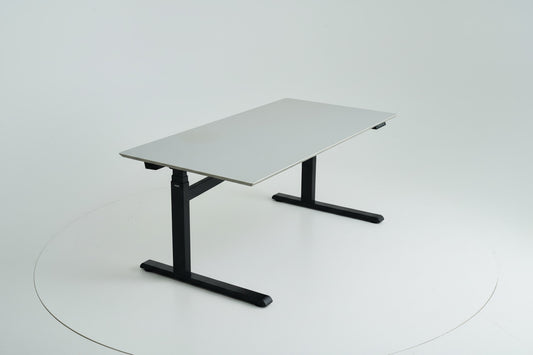 Duba B8 hæve-sænkebord 160x80 cm i lysegrå linoleum set fra skrå vinkel med affasede kanter og kabelbakke