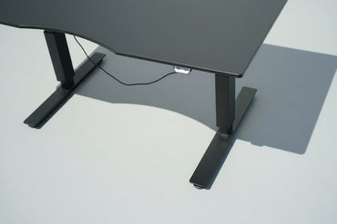 Close up af EFG hæve-sænkebord med sort linoleumsbordplade, ergonomisk mavebue og eksklusiv overflade.