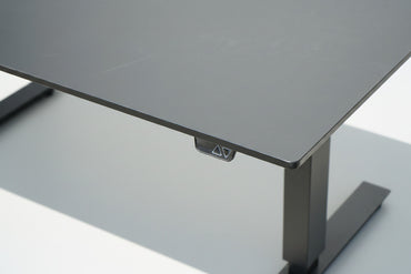 Close up af EFG hæve-sænkebord med slidstærk sort linoleumsbordplade i høj kvalitet og elegant finish.