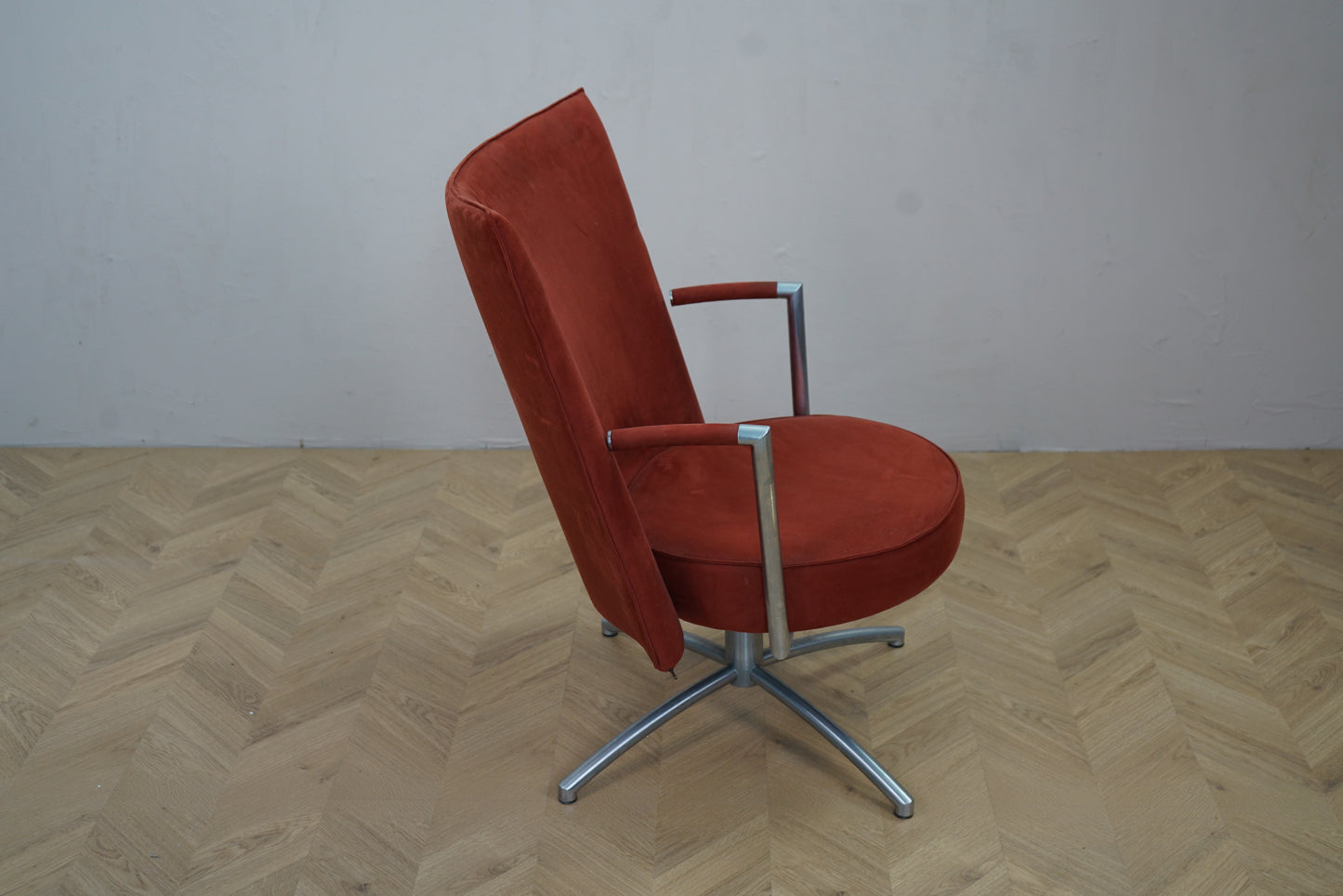 Erik Jørgensen loungestol i rød velour med slanke armlæn og metal-drejefod set fra siden
