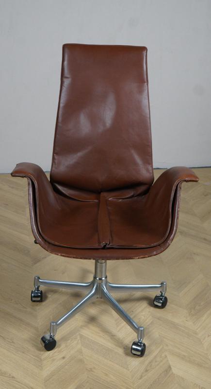 FK Bucket Chair designet af Kastholm og Fabricius i brun læder – set forfra med hjul og femstjernet fod