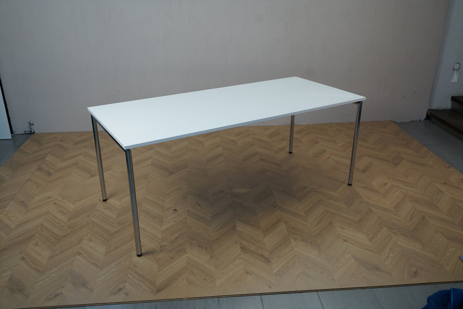 Four Design bord 180x80 cm med hvid bordplade og kromben set fra skrå vinkel – ideelt som spisebord, mødebord eller konferencebord