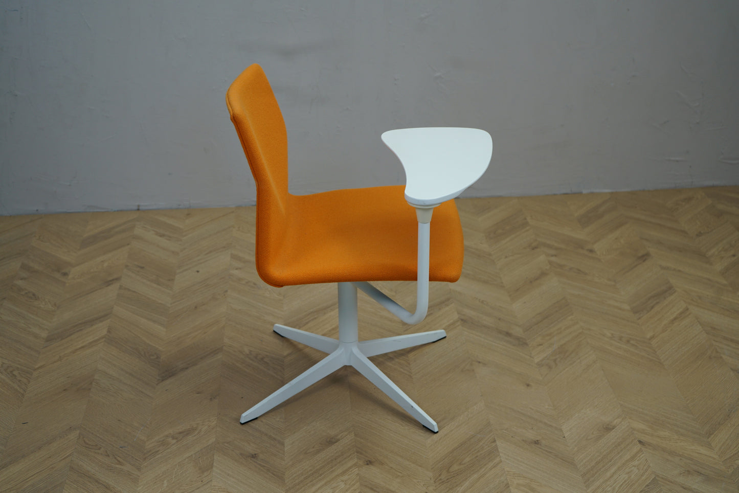 Four Design FourCast stol i orange set fra siden med drejbar skriveplade.