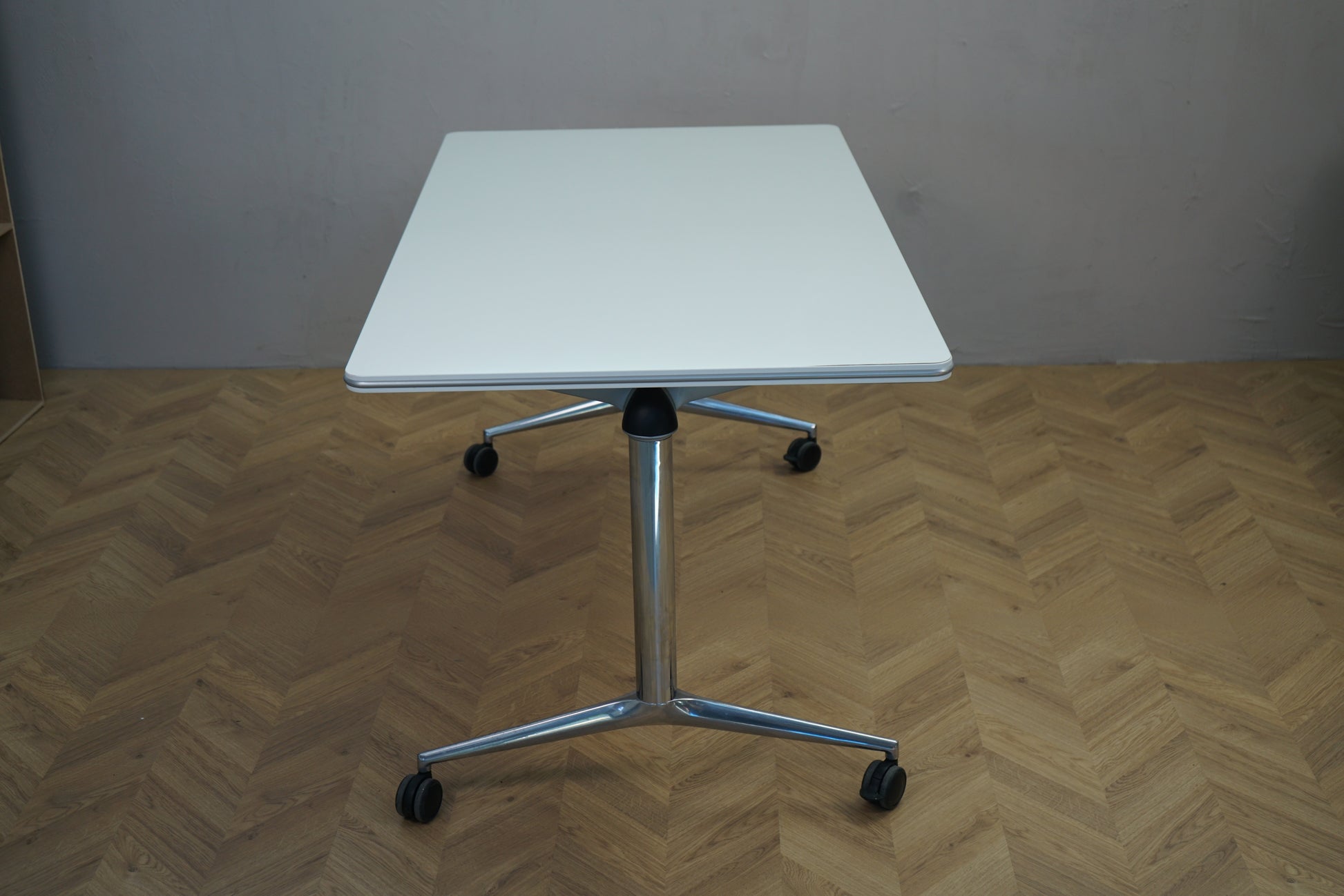 Four Design sammenklappeligt bord på hjul 140x80 cm i hvid – set fra siden med krom ben og fleksibel konstruktion.