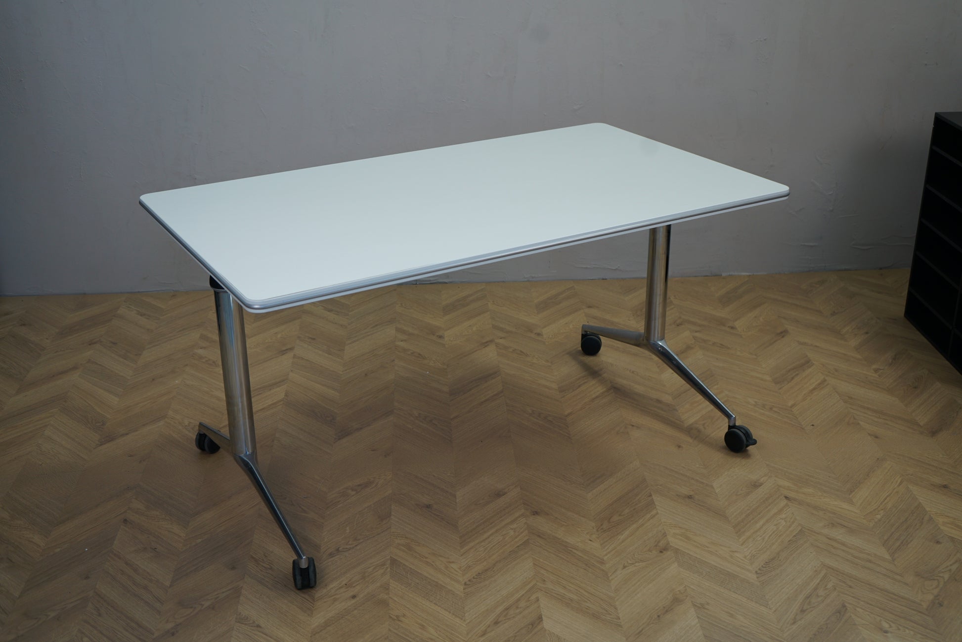 Four Design klapbord på hjul i hvid 140x80 cm set fra skrå vinkel – fleksibelt sammenklappeligt bord til kontor og mødelokale.