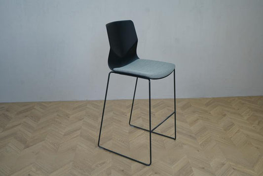 Skrå visning af Four Sure barstol fra Four Design – sort plastskal, gråmeleret Hallingdal sæde og sort medestel.