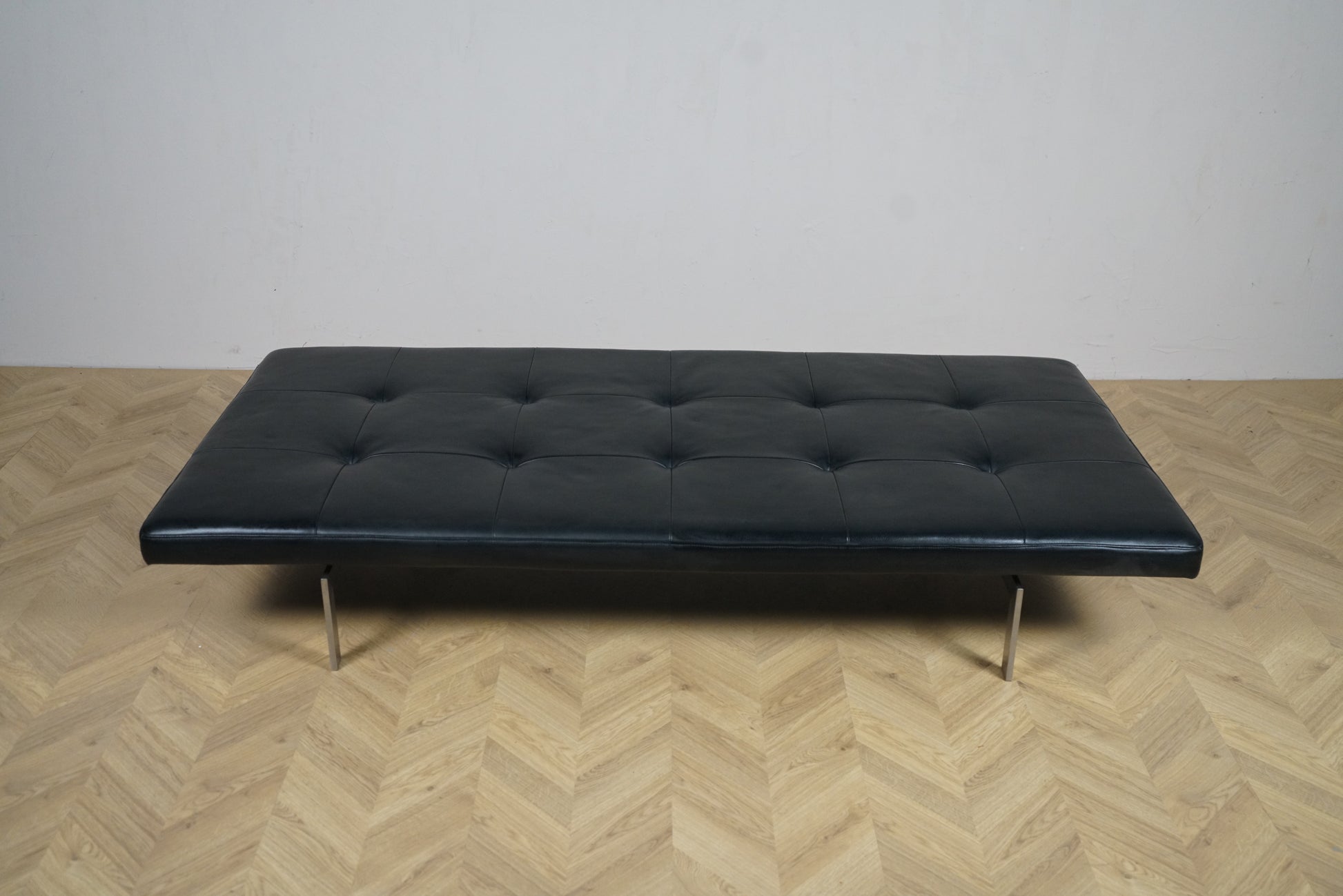 Frontbillede af Fritz Hansen PK80 dagseng i sort læder og forkromede stålben, design Poul Kjærholm.