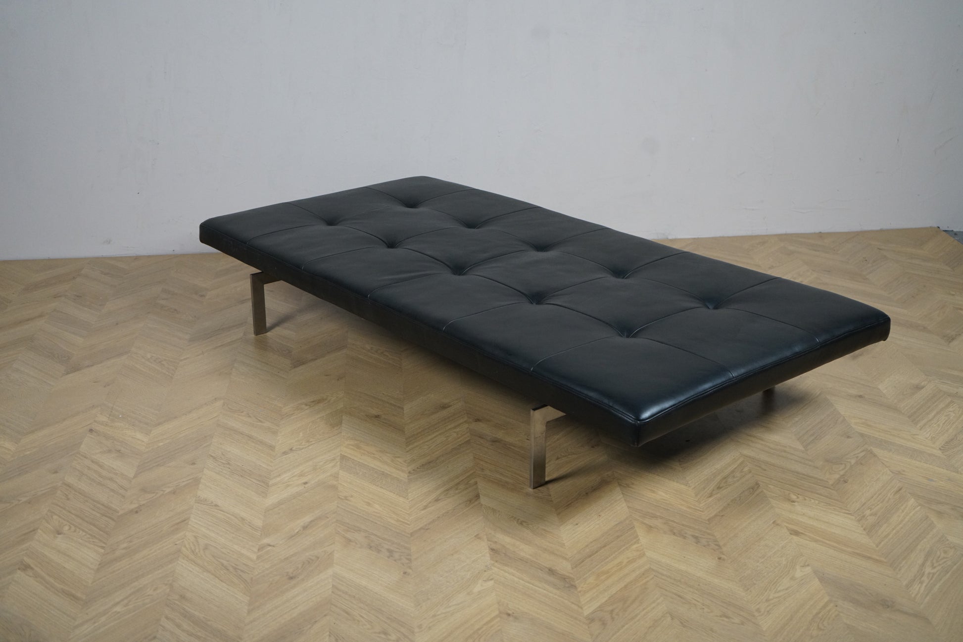 Fritz Hansen PK80 dagseng i sort læder set skrå fra venstre, design Poul Kjærholm, klassisk dansk design.