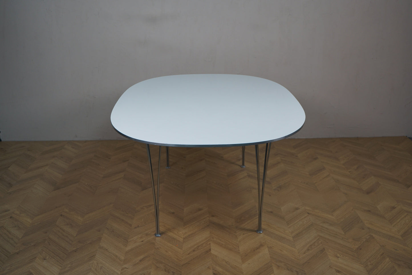 Fritz Hansen Super-Ellipse spisebord 180x120 med hvid laminatbordplade og kromben, set fra siden.